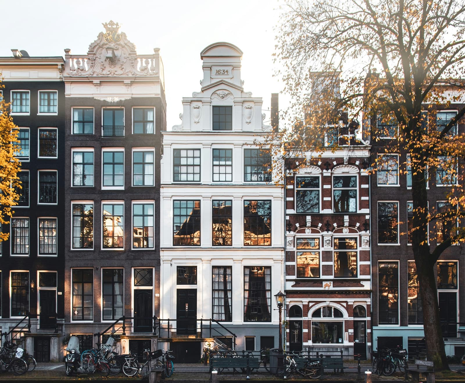 Canal houses in Amsterdam in autumn light, reflected in the water.