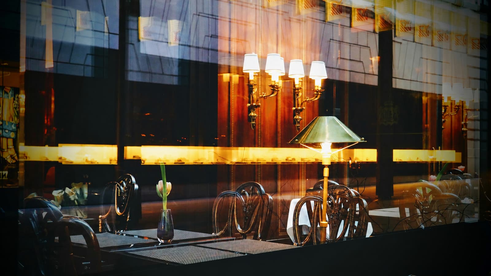 A table set for a conversation by the window, in warm lamplight.
